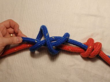 .. Seile mit den Enden gegeneinander legen. Mit dem einen Seil einen Überhandknoten im Uhrzeigersinn um das andere Seil legen.