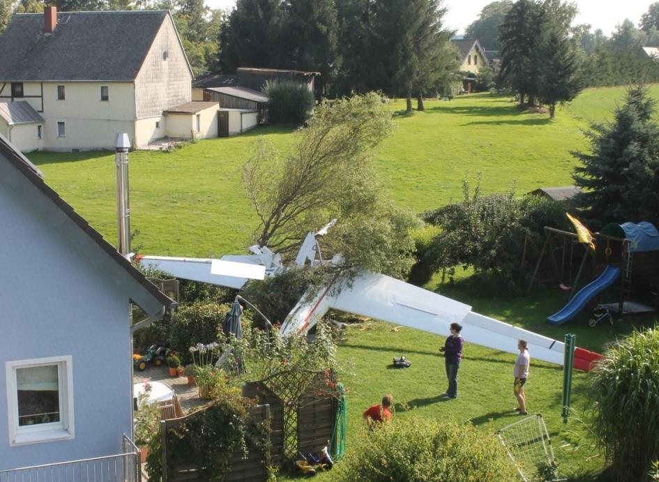 Unfallstelle Foto: BFU Das Flugzeugwrack befand sich im Garten eines Einfamilienhauses in Rückenlage auf einem zerstörten Baum.