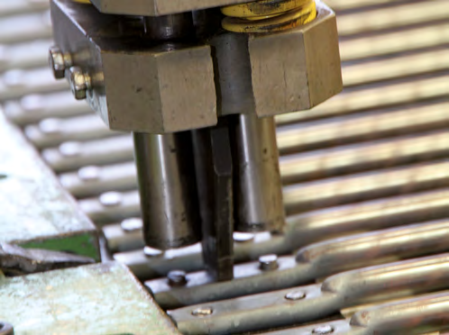 Nietabteilung In der Nietdrück Maschine werden die fertigen Riemen mit Nietplatten und Nieten bestückt. Detailaufnahme des automatischen Nietvorganges.