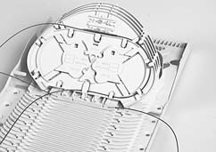 3.3 Routing für SE und SC Management 3.2.6 Kassettendeckel auf letzte Kassette aufsetzen. 3.3.1 Spleißschutz in Spleißschutzhalter auf Kassette einsetzen und sicherstellen, daß die Fasern nach links und nach rechts eine sanfte Schlaufe bilden (Siehe Bild).