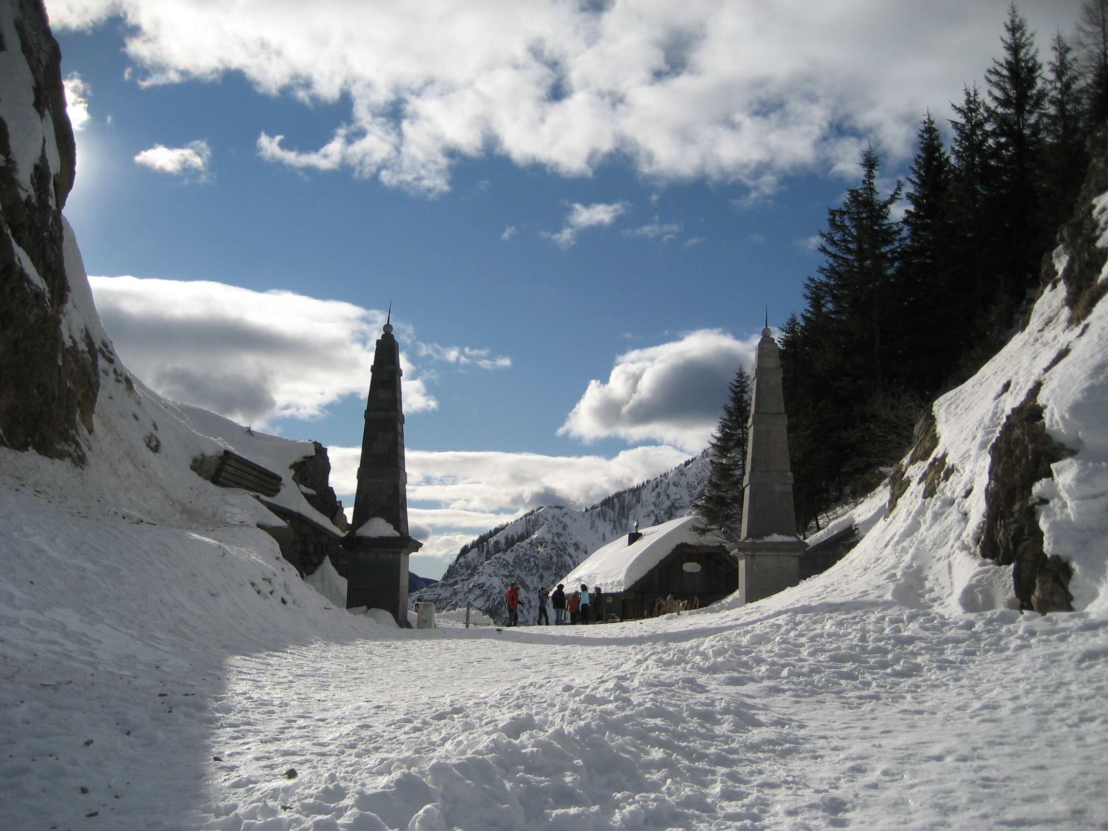 Winterliches Stimmungsbild am Loiblpaß: im Vordergrund die zwei historischen Obelisken von 1728, die heute die