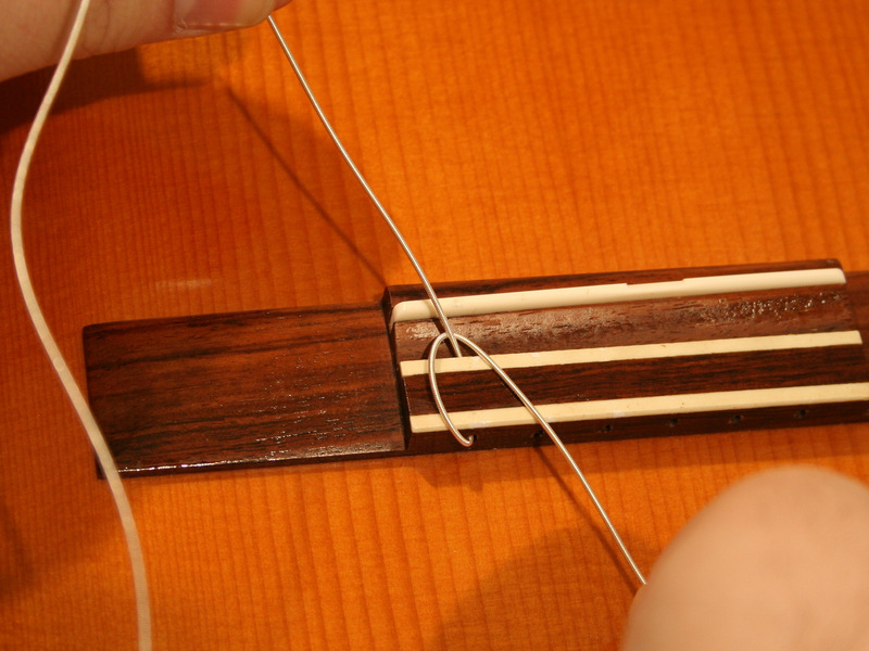 Schritt 3 Themen-Strings durch die Brücke Die ersten drei Saiten (Low-E, A und D), haben dicke und federnde Enden; die drei dünnsten