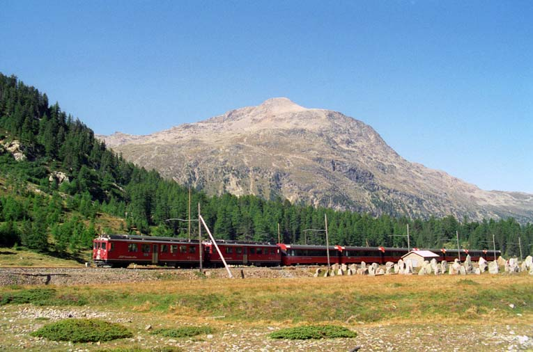 Bild T18-2: Der Bernina-Express aus Bild T18-1 ist nun ein paar hundert Meter weitergefahren. Ein Schweizer Kuriosum sind die Panzersperren beim Wald von Chapütschöl.