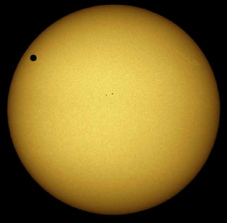 Ein Mann blickt durch ein Teleskop auf die bereits verfinsterte Sonne