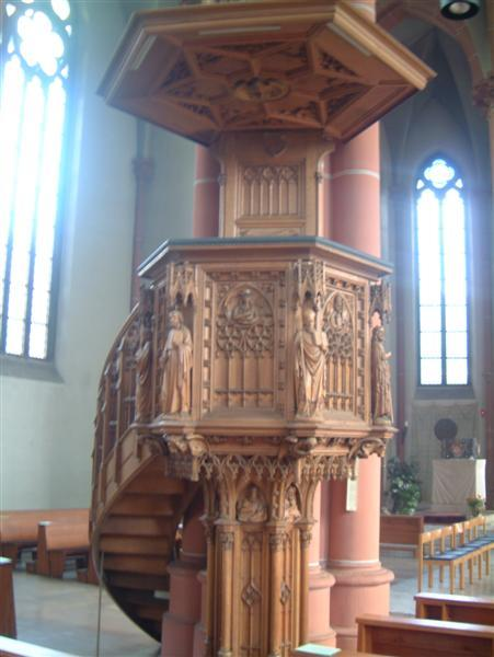 Die neugotische Kanzel von 1899 im vorderen, linken Teil des Hauptschiffs, wird nicht mehr benutzt. Bis zur Aufstellung der Ambonen im Altarraum war sie der Ort der Verkündigung des Wortes Gottes.