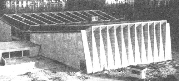 Eine Platte, die entsprechend den gedrückten Zonen wellenförmig verläuft, ist im Dach zur gefalteten Struktur hinzugefügt worden, um die statische Effizienz zu steigern und den Beton am bestmöglichen