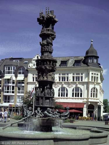 4. Görresplatz In der Mitte des Görresplatzes steht ein Brunnen mit einer ca. 10 m hohen Historiensäule.