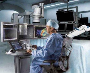 Abbildung 10: Sensei Kathetersystem im Elektrophysiologie Labor: Der herkömmliche Ablationskatheter wird in eine steuerbare Schleuse eingeführt, welche über einen robotischen Arm
