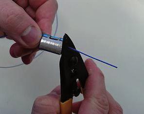 3 Entfernen der Isolierung des Glasfaserkabels Legen Sie die Abisolierzange am Rand des Kopfstücks mit der eingelegten Faser an.
