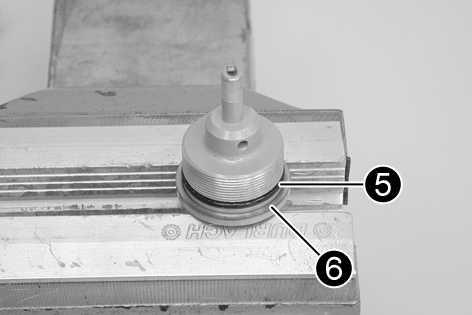 14) Druckstufenaufnahme mit Schonbacken in einen Schraubstock einspannen.
