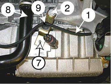 5 4/8 S Värmaren monteras på oljetråget i F. Demontera kabeln () från fästet på oljetråget och ta av kontakten till sensorn på oljetråget. Rengör oljetråget noga i området där värmaren skall monteras.