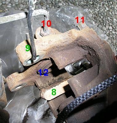 Abb.4: Während der Bremssattel innen mit Hilfe einer Zündkerzenbürste (8) gereinigt wird, sollte er mit einer