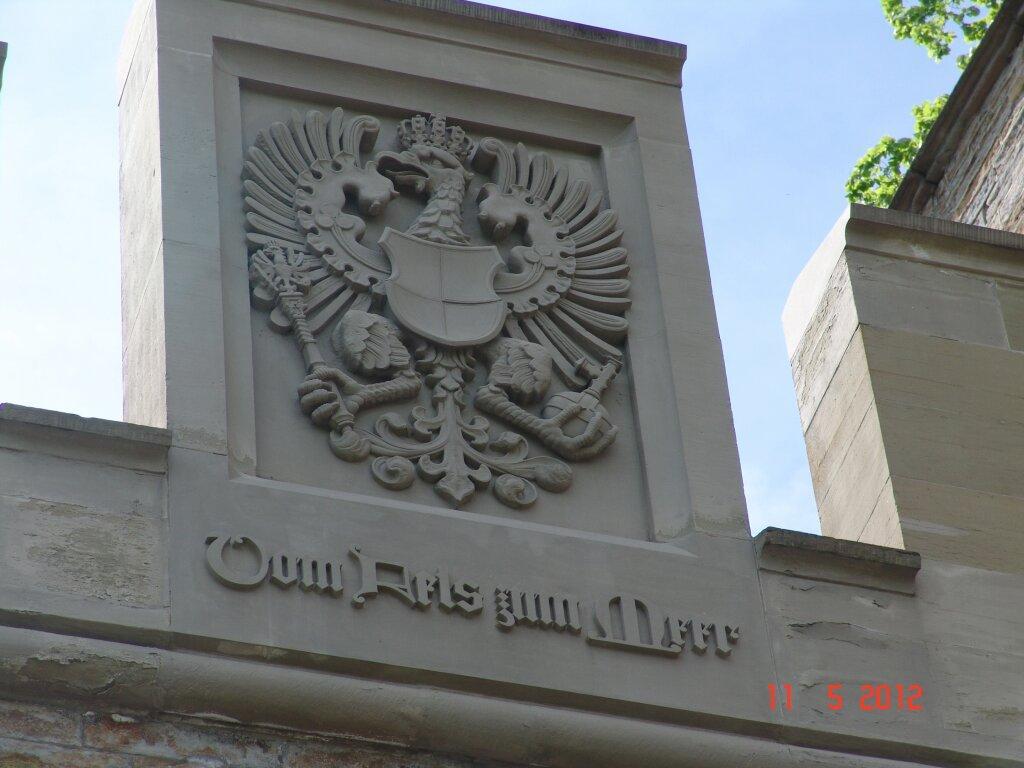 Über dem Torbogen der Burg das Wappen, unter ihm steht deshalb Vom Fels