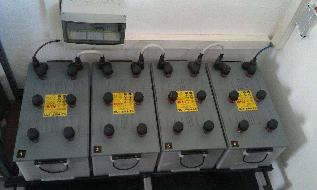 Die im vorigen Bild gezeigte Technik, bestehend aus dem Wechselrichter (links) der Verteilung und Absicherung (im Schrank in der Mitte) und dem Batterieladeregler (rechts), wurde an der Wand, direkt