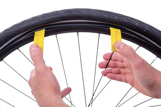 Lassen Sie die Luft durch Druck auf den Ventilstift in der Mitte des Ventils vollständig ab. Lösen Sie mit Reifenhebern den Reifen auf einer Seite von der Felge. Verwenden Sie ggf.
