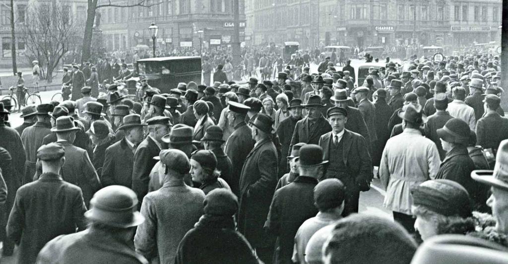 APRIL 1933 Die SS verbrennt die schwarz-rot-goldene Flagge, die rote Fahne und die Verbandsfahnen. Eine große Menschenmenge beobachtet die Machtdemonstration der Nationalsozialisten. Am 1.