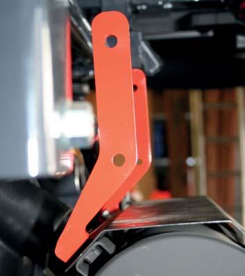 Schrauben aus dem Metallkit und den Abstandshülsen am Umsturzsicherheitsbügel montieren.