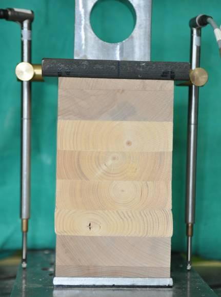 104 Querdruck Hybrid-Brettschichtholz kung. Hier ist die seitliche Ausdehnung des Holzes rechtwinklig zur Faser knapp oberhalb der unteren Buchenlamelle deutlich zu erkennen.