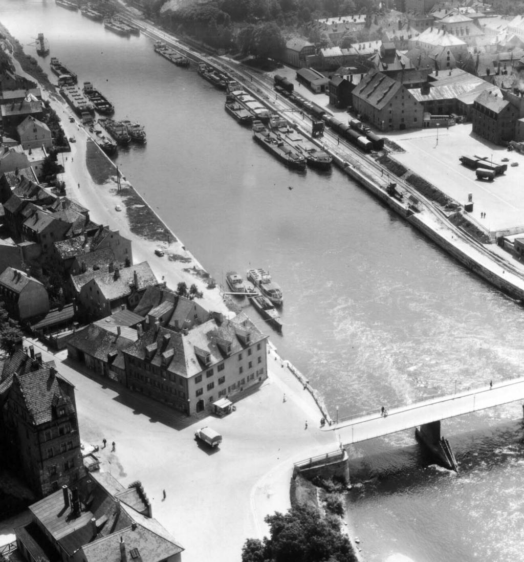 Nördlicher Brückenkopf der Eisernen Brücke Bis zur Sprengung im Jahre 1945 verband eine Brücke aus Eisengitterträgern den Unteren Wöhrd mit der Altstadt. Die Maschinenfabrik J. Maffei, die im 19.