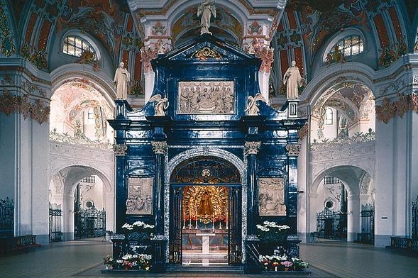 Wer die Kirche betritt, steht in einem grossen, achteckigen Raum und erblickt vor sich die Marienkapelle aus schwarzem Marmor. Es ist die Gebetsstätte des ersten Einsiedlers Meinrad.