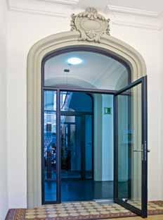 Die filigrane Pfosten/Riegel-Fassade und die darin integrierten Eingangstüren in der Brandschutzklasse EI30 bilden die Abtrennung zwischen Foyer und Konferenzraum.