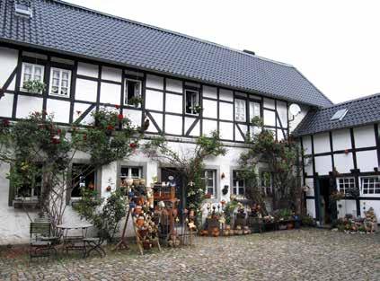 Vor den zurücktretenden Höhenzügen der Nordeifel erblickt man in der Wehebachniederung den Turmhelm der Wenauer Kirche, ein Teil der seit 800 Jahren bestehenden Klosteranlage der