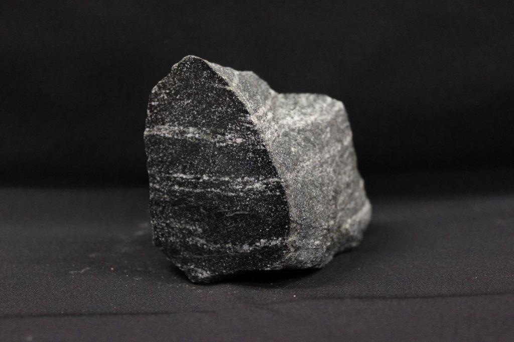 Nr. 12: Amphibolit Druck und Temperatur - die metamorphen Größen Bei diesem dunklen, gebänderten Gestein handelt es sich um einen Bänderamphibolit. Amphibolite sind metamorphe Gesteine.
