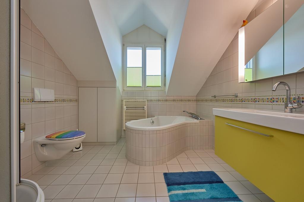 Bild oben: Badezimmer mit Badewanne, Dusche,
