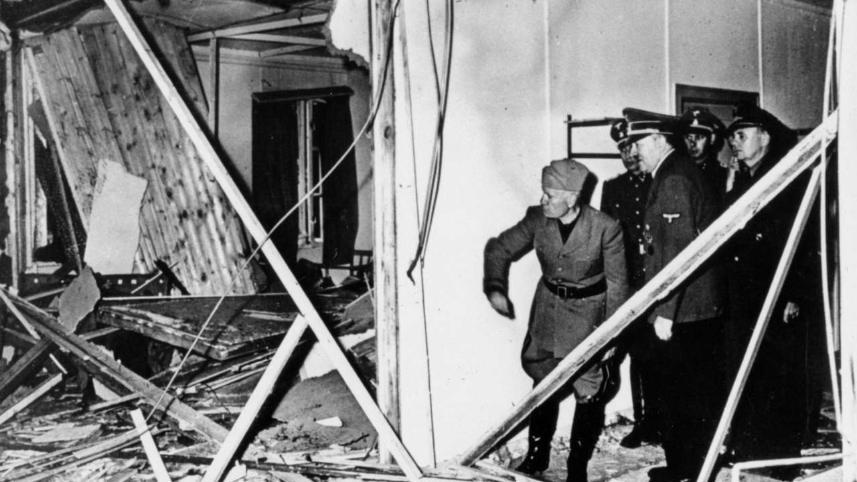 Himmler begrüßt den Duce wie befohlen am Bahnhof, fährt mit ihm zu Hitler. Vor der zerstörten Baracke entsteht das bekannte Foto der beiden Diktatoren.
