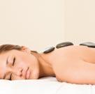 Bei einer Massage mit heißen Steinen aus der Lahn wird die Durchblutung gefördert, der Stoffwechsel angeregt und die