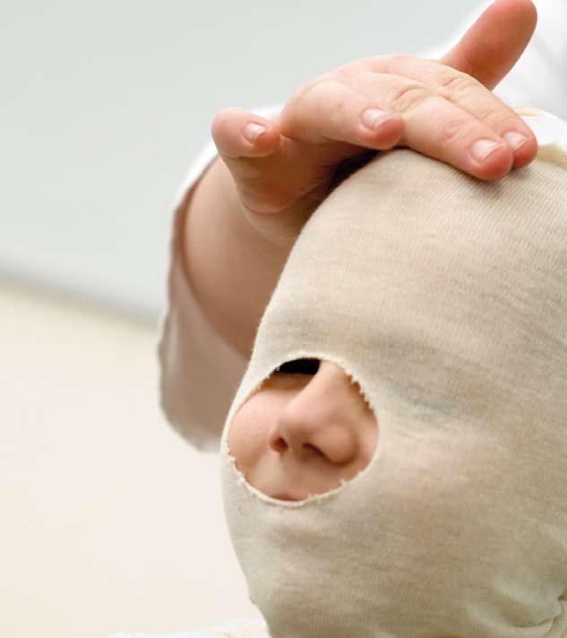 16 Maske herstellen Die Kunststoffbinden werden in Wasser eingetaucht und um den Kopf herumgewickelt. Die Nase bleibt frei.