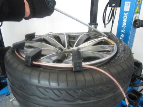 Montageeisen ansetzen (geschmiert) Bei Runflat-Reifen zusätzlich die Wulstniederhalterkette gegenüber des Montagekopf verwenden.