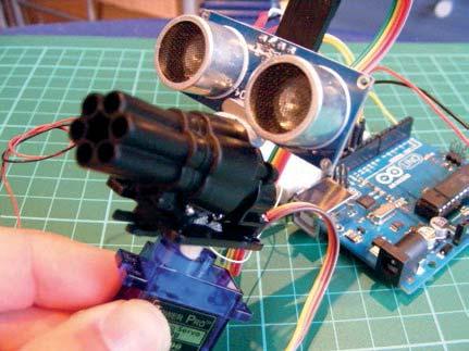 So funktioniert es Wir verbinden den kleinen Raketenwerfer und den Ultraschallsensor mit dem Servo-Arm (siehe Abbildung 20-1), sodass der Servomotor Kanone und Sensor um 180 Grad drehen kann, was dem