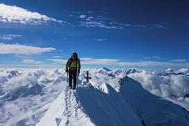 Zu Beginn des Abstiegs kamen 2 Bergsteiger den Grat entlang. Hinter ihnen lag ein reizvoller Wolkenhimmel über Italien.
