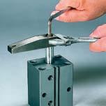 Spannarmdemontage: 1) Spannarm mit Schraubenschlüssel festhalten und Schraube lösen.