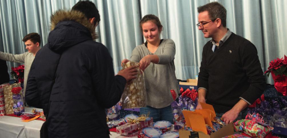 78 G4-EC8 Freiwillige Helfer der R+V Versicherung überreichen bei der Weihnachtsfeier der Wiesbadener Tafel Geschenke an die Jugendlichen.