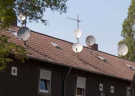 [ - ] [ - ] Beliebig angebrachte Satellitenanlagen stören die ansonsten ruhige Dachlandschaft Eine uneinheitliche Dacheindeckung und willkürliche Gestaltung zerreißt die Hausgruppe Um die