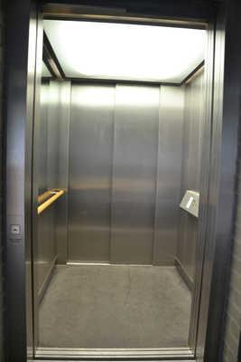 Der Aufzug ist hell und blendfrei ausgeleuchtet. Die sind auf einem horizontalen Bedientableau angeordnet. Die bzw. die Beschilderung ist visuell kontrastreich gestaltet. Die bzw. die Beschilderung sind/ist taktil erfassbar.