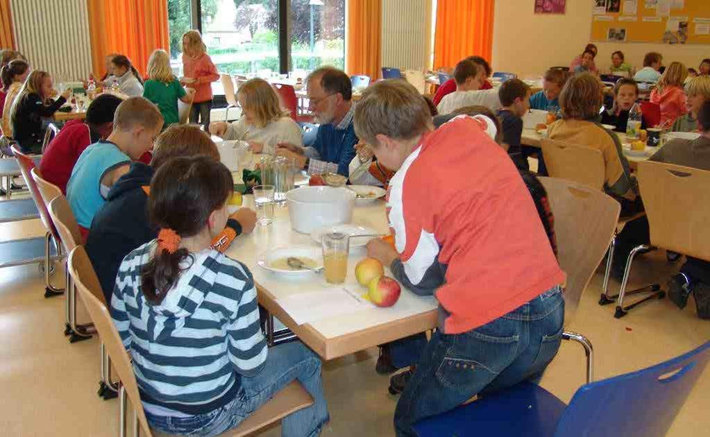 Lehrkräfte essen mit den Schülerinnen und Schülern gemeinsam.