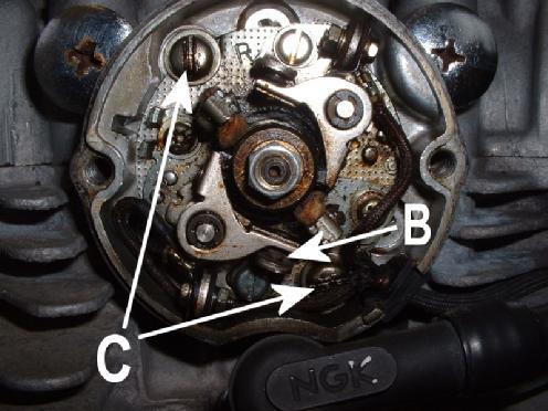 Unterbrecherplatte entfernen (linke Motorseite) Stelle den Motor durch Drehen der Kurbelwelle im Gegenuhrzeigersinn auf den Zündpunkt (Pfeil A) des linken Zylinders.