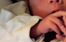 Das Baby führt die Hände zur Körpermittellinie in die Nähe seines Gesichts, macht Suchbewegungen und saugt