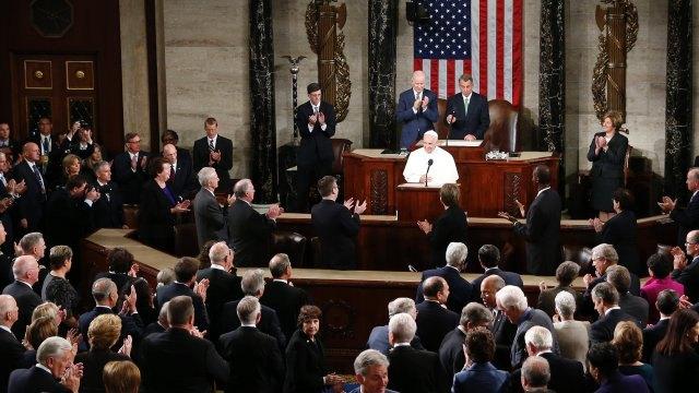 Members of the House and Senate applause as Pope Francis begins his address before a