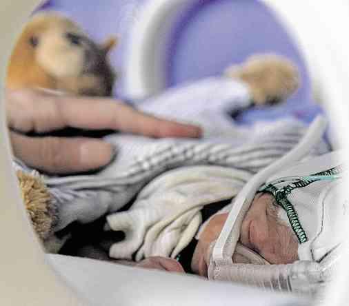 Er kam nach sieben Monaten zur Welt und wog 710 Gramm. Seine Mutter Tanja Bauer sitzt neben ihm am durchsichtigen Brutkasten.