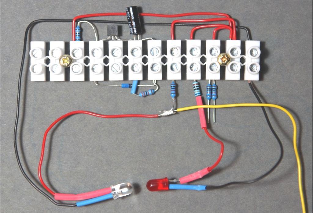 Die Anschlüsse der LED-1 etwas auseinander biegen und an den kurzen Anschluss (Kathode) einen schwarzen Draht (ca. 10 cm) anlöten. An den langen Anschluss (Anode) der LED-1 einen roten Draht (ca.