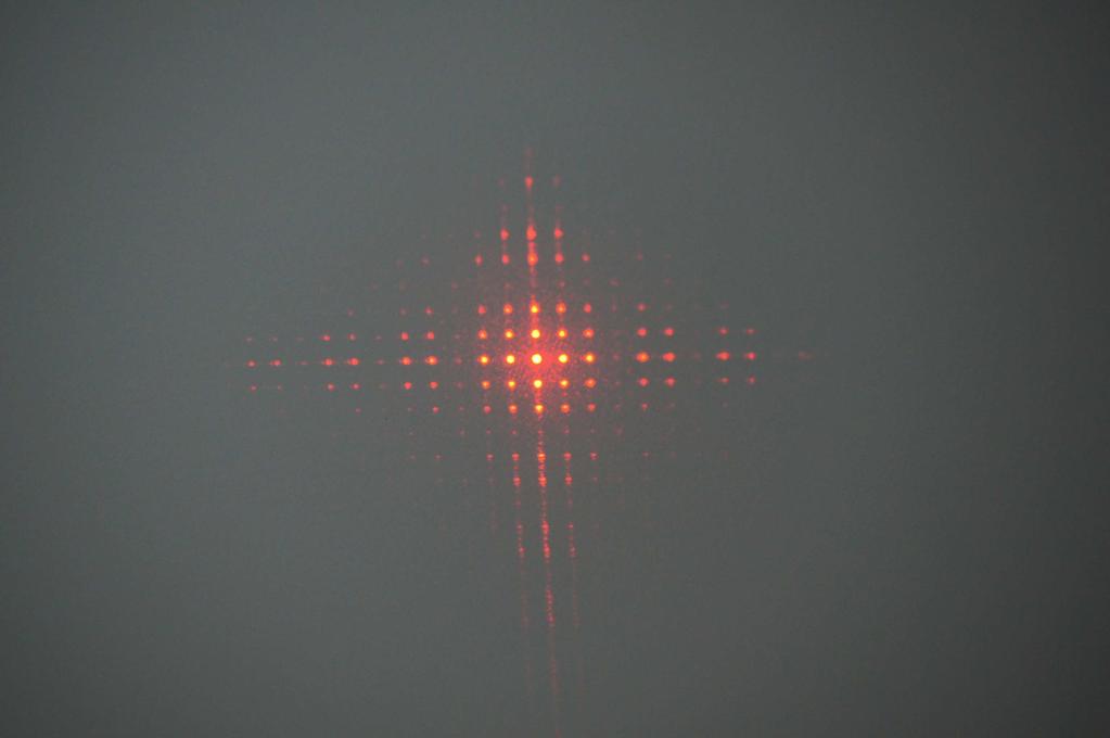 sichtbar sind. Abbildung 5 zeigt den Aufbau mit Laser und Kreuzgitter.