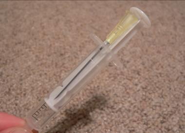 6. Die Nadel wird sofort nach Gebrauch sicher entsorgt, z.b. in der Spritze (s. Abbildung) oder in einem Spezialbehälter.