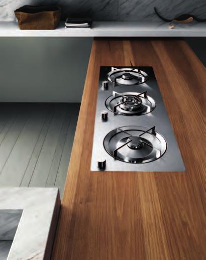 >a single plank of 6 cm thick solid toulipier wood treated with wax becomes a peninsular unit and a base for flush-fitting in-line circular burners.