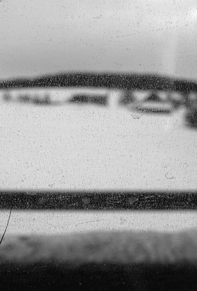 Andrina Keller Die fotografische Arbeit Line / Nothing really happens zeigt das sich wiederholende Bild eines Blickes durch die vom Schnee, Salz und Abgas verschmutzten Scheiben eines Buses und gibt