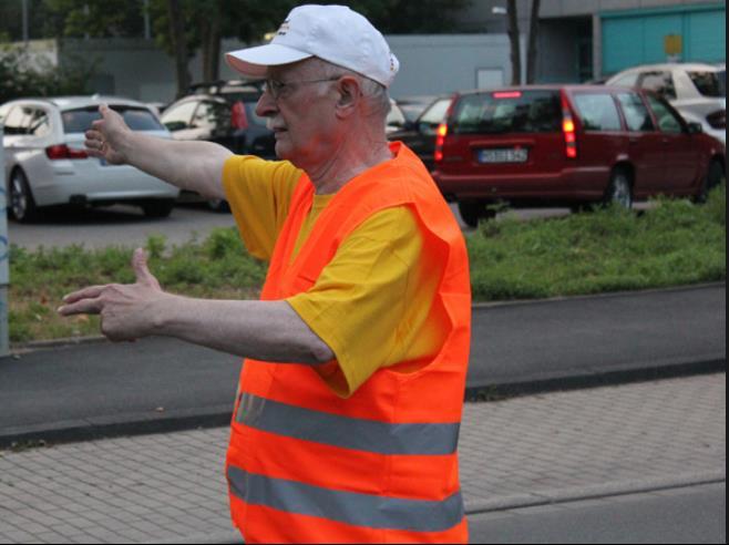 Parkplatz-Einweiser trägt eine Warnweste und ist dadurch klar