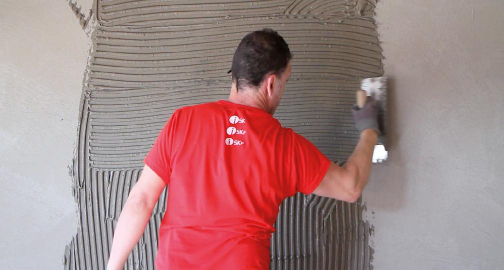 Der Zementkleber muss immer im rechten Winkel zur langen Seite der Platte aufgestrichen werden, und zwar sowohl an der Wand, als auch auf dem Fliesenteil, damit evtl.